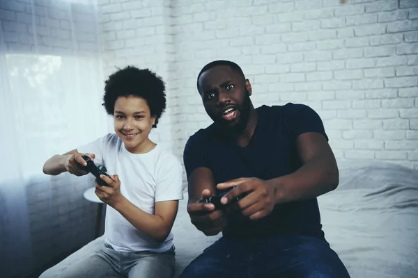 アフリカ系アメリカ人の父と息子がビデオ ゲームを果たしています。 — ストック写真