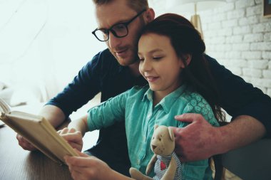 Kırmızı saçlı baba bardaklarda kitap okur