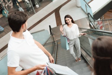 Baba, anne ve kızı alışveriş alışveriş merkezinde yürüyen merdiven üzerinde gidiyorlar.