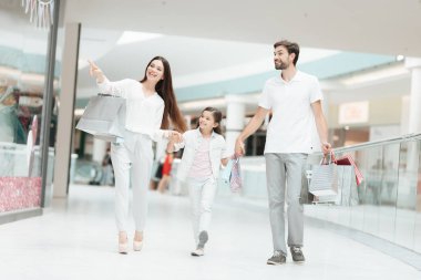 Aile, Baba, anne ve kızı başka bir mağazada alışveriş merkezi için yürüyor.