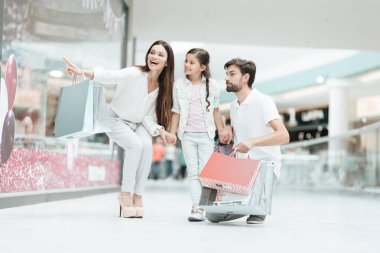 Aile, Baba, anne ve kızı başka bir mağazada alışveriş merkezi için yürüyor.