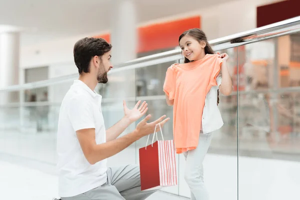 Father and daughter are taking out new sweater in shopping mall.