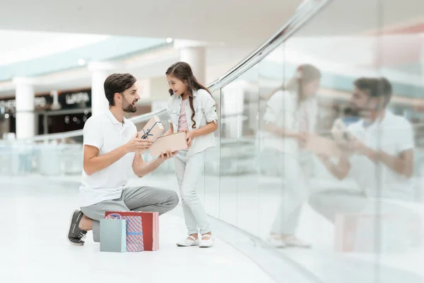 Vader en dochter opent nieuwe cadeau voor het meisje in winkelcentrum. — Stockfoto