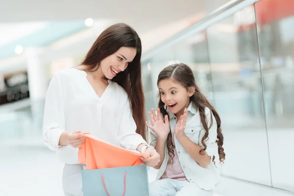Mãe e filha estão tirando camisola nova no shopping center. Menina está animada . — Fotografia de Stock