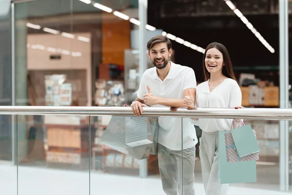 Man en vrouw in winkelcentrum. Paar geeft duimen omhoog op camera. — Stockfoto