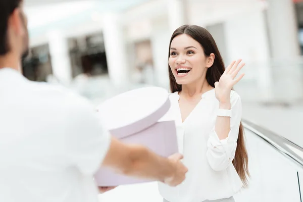 Homem e mulher no centro comercial. Homem apresenta mulher com nova caixa redonda . — Fotografia de Stock