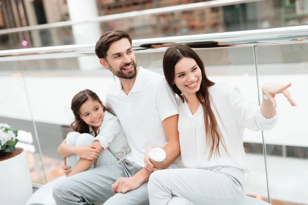 Dreiköpfige Familie, Vater, Mutter und Tochter sitzen auf Bank in Einkaufszentrum. — Stockfoto