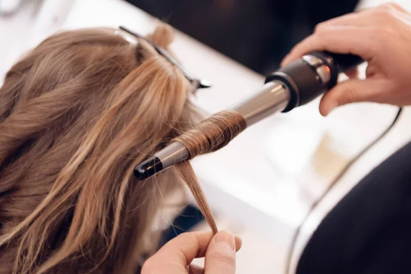 De cerca. Mujer de pelo castaño hace rizar el cabello en el salón de belleza. Peluquero hacer ola de pelo para mujer . —  Fotos de Stock