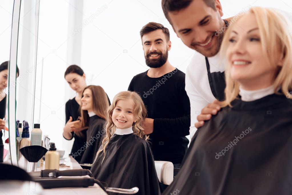 Several stylists make hairstyle for women of different ages in beauty salon.