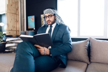 Arap işadamı kanepede oda ofis, not alma.
