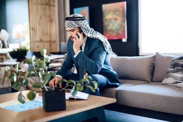 Arabo uomo d'affari che parla al telefono sul divano in ufficio . — Foto Stock