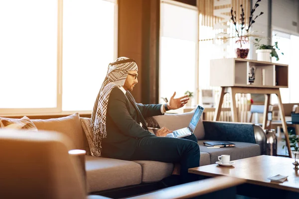 Arabischer Geschäftsmann auf Laptop auf Couch im Büro. — Stockfoto