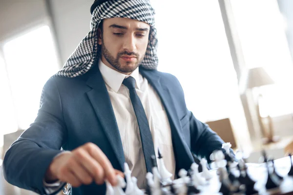 Arabisk affärsman spela schack vid bord på hotellrum. — Stockfoto