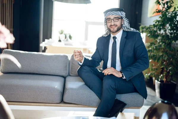 Uomo d'affari arabo con perline sul divano in camera d'albergo . — Foto Stock