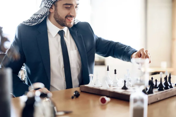 Arabisk affärsman spela schack vid bord på hotellrum. — Stockfoto