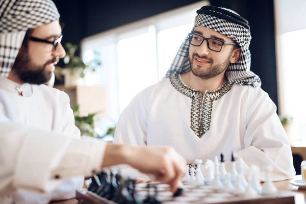 Två arabiska affärsmän som spelar schack vid bordet på hotellrummet. — Stockfoto