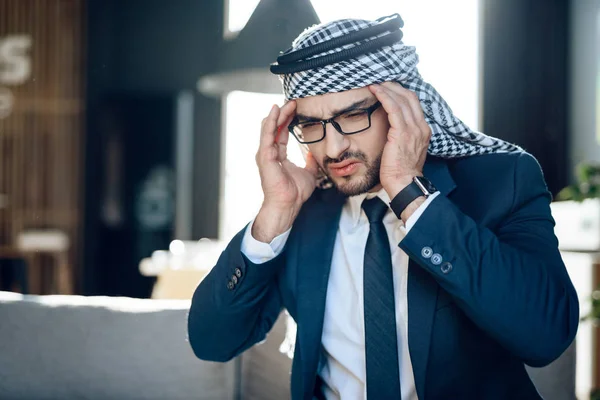 Benadrukt Arabische zakenman op Bank op hotelkamer. — Stockfoto