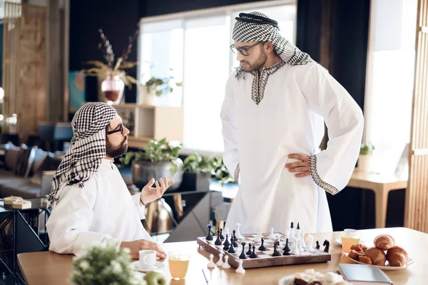 Twee Arabische zakenlieden ruzie spelen Schaken op tafel op hotelkamer. — Stockfoto