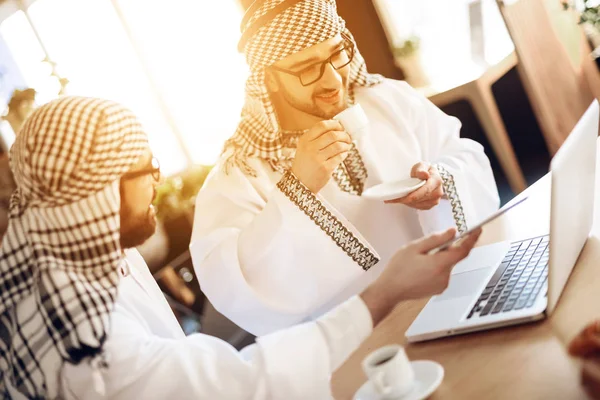 Två arabiska affärsmän dricka kaffe vid bordet på hotellrum. — Stockfoto