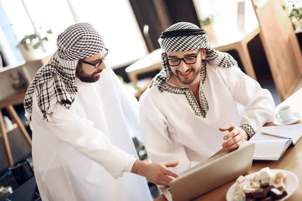 Twee Arabische zakenlieden op laptop aan tafel in hotelkamer. — Stockfoto