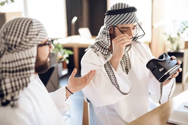 Två arabiska affärsmän använder vr vid bord på hotellrum. — Stockfoto