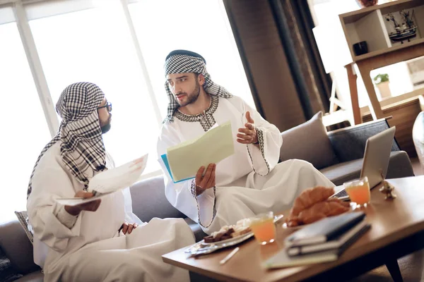 Twee Arabische zakenlieden met papieren op tafel op hotelkamer. — Stockfoto