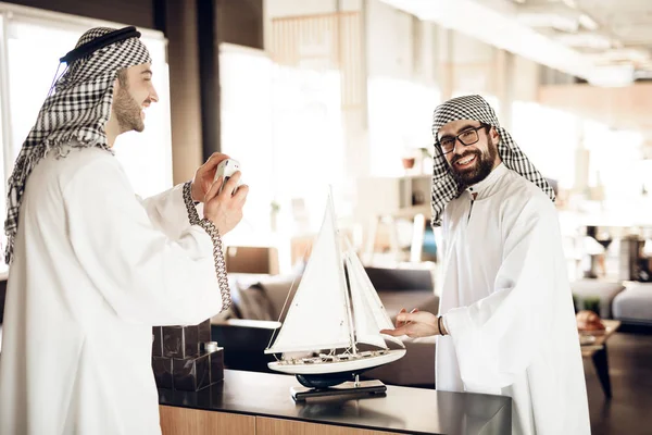 Dos hombres de negocios árabes con yate modelo en la mesa en la habitación del hotel . — Foto de Stock