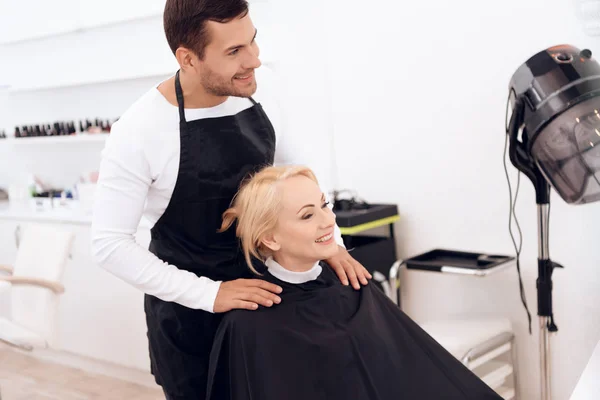 Estilista viste cuello de peluquería en el cuello de la mujer madura. Corte de pelo femenino . —  Fotos de Stock