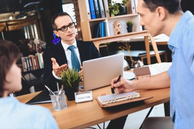 Emlak ofis masasında oturuyor. Babası yeni apartment hakkında notlar alıyor.