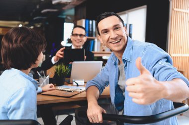 Emlak ofis masasında oturuyor. Adam baba ve oğul için tablet gösterilen.