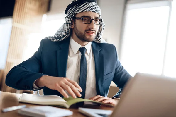 Arabischer Geschäftsmann macht sich Notizen am Tisch im Büro. — Stockfoto