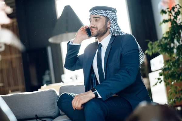 Arabische zakenman spreken op telefoon op Bank bij hotel. — Stockfoto