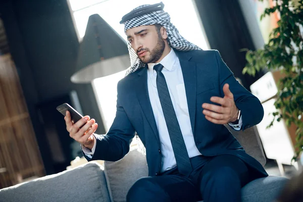 Arabische zakenman spreken op telefoon op Bank bij hotel. — Stockfoto