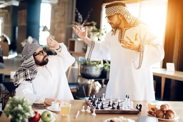 Twee Arabische zakenlieden ruzie spelen Schaken op tafel op hotelkamer. — Stockfoto