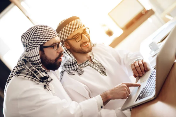 Två arabiska affärsmän på laptop vid bord på hotellrum. — Stockfoto