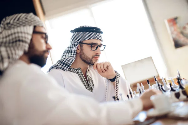 Deux hommes d'affaires arabes jouant aux échecs à table à la chambre d'hôtel . — Photo