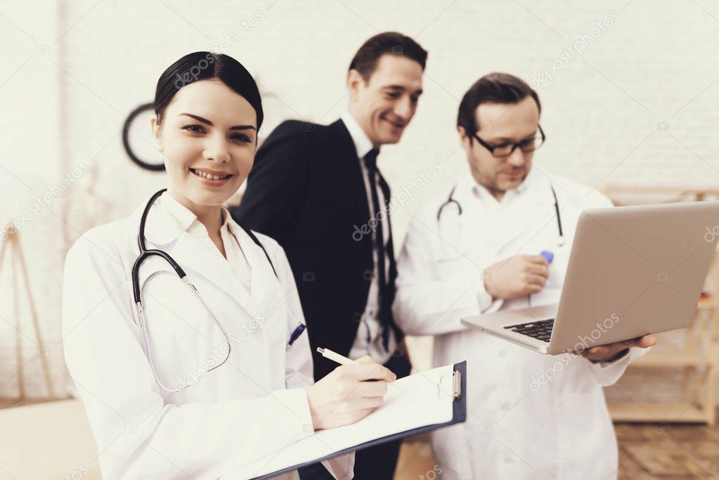 Skilled doctor shows on laptop results of medical examination of successful businessman in office.