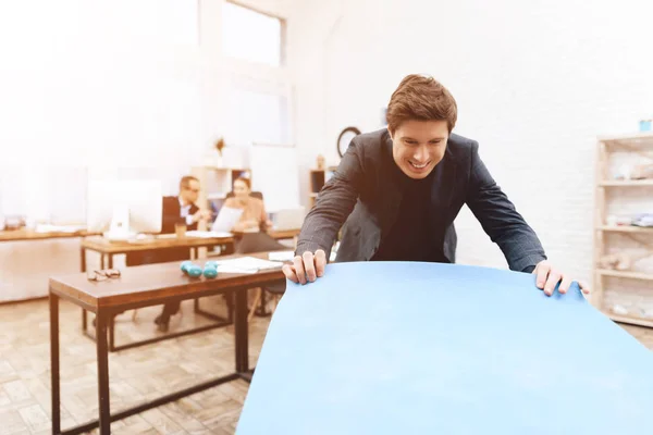 Een man doet gymnastische oefeningen op het werk. — Stockfoto