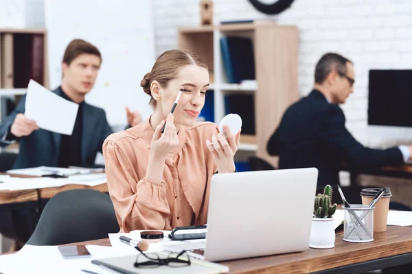 Bir kadın onun işyerinde makyaj yapıyor.