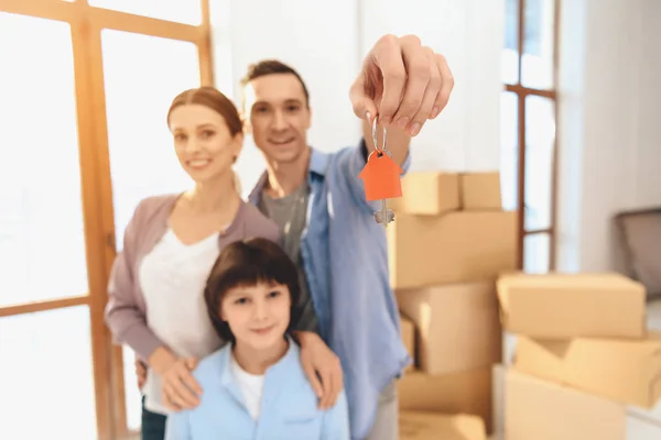 Padre, madre e hijo en apartamento nuevo con cajas de cartón. Papá tiene las llaves. . — Foto de Stock