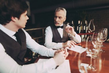 Kendine güvenen genç ve yaşlı sommeliers restoranda şarap içecek kalitesini tartışmak.