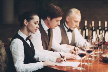 Grup sommeliers restoranda şarap kart yapmak. Seçkin alkollü içecekler tatma.