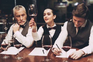 Güzel kadın sommelier şarap tutarak ve çökeller tatma.