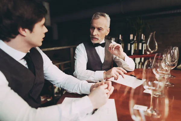 Confident young and old sommeliers discuss quality of wine drink in restaurant. — Stock Photo, Image