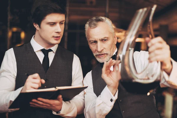 Two men sommelier tasting wine in restaurant looking at decanter with wine. — Stock Photo, Image