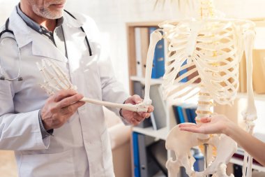 Doktor stetoskop ve erkek hasta Office ile. Doktor iskelet'ın el gösterilen.