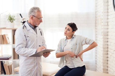 Doktor stetoskop ve erkek hasta Office ile. Hastanın yan acıyor.