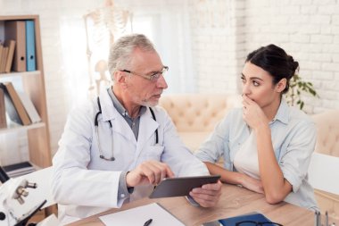 Doktor stetoskop ve erkek hasta Office ile. Doktor tablet kullanma.