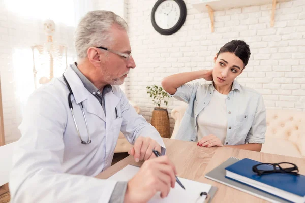 Médico con estetoscopio y paciente femenina en consulta. El cuello del paciente duele . — Foto de Stock