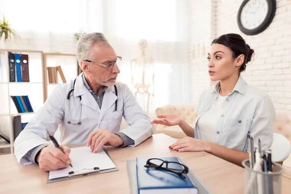 Médico con estetoscopio y paciente femenina en consulta. El paciente está diciendo síntomas . — Foto de Stock